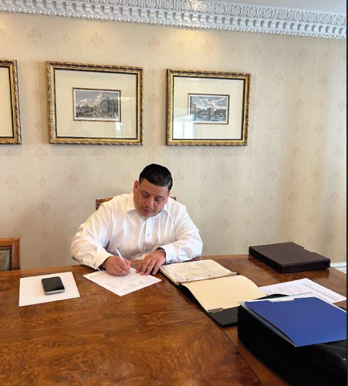 Business specialist Marcelo Umanzor Blanco carefully reviewing official IRS Federal Tax ID (EIN) documentation in his professional Los Angeles office.