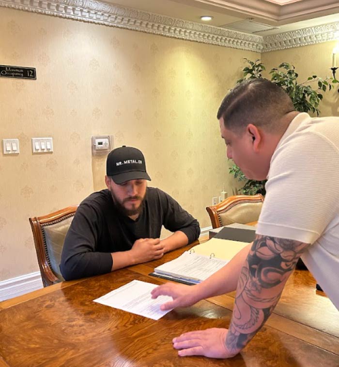 A professional Pro Business Solutions consultant reviewing official corporate documents and offering strategic business consulting to a focused client in a conference room.