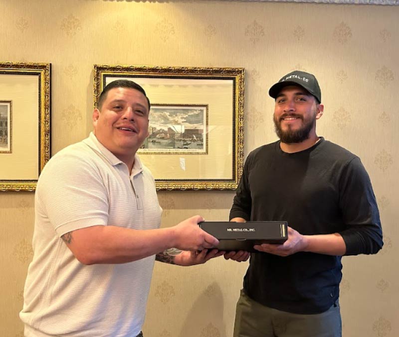Pro Business Solutions consultant handing over a completed corporate kit to a smiling new business owner of Mr. Metal Co. Inc., symbolizing successful S-Corporation formation