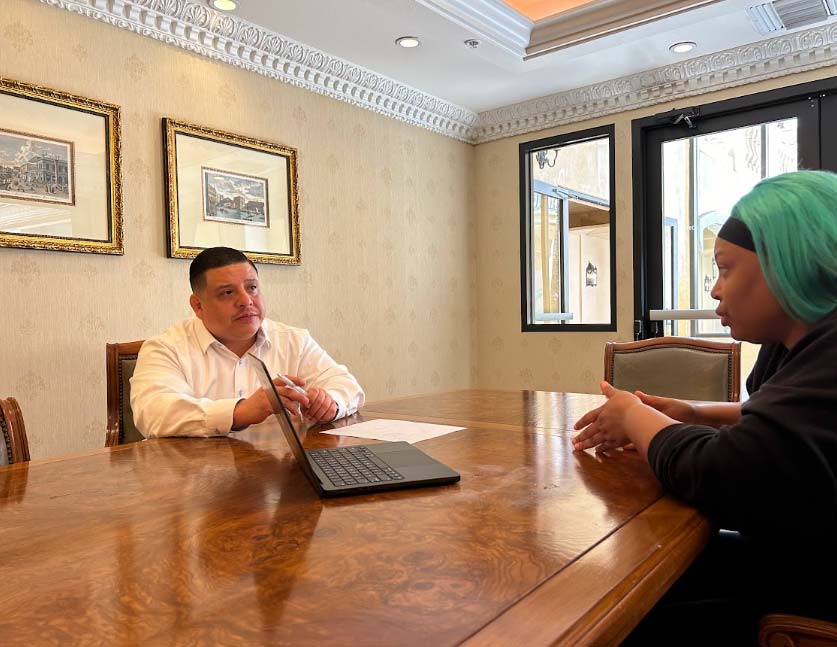 Marcelo Umanzor Blanco conducting a one-on-one business consultation with a client in an executive conference room